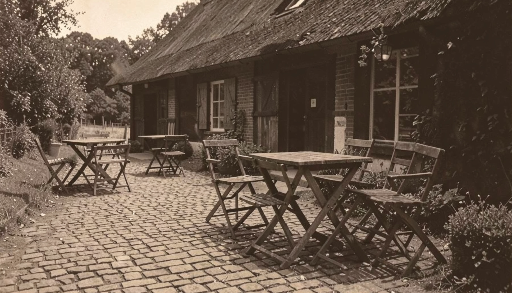 Houten banken en tafels op een grindpad bij een boerderij, in gedempte aardetinten en zachte schaduwen.
